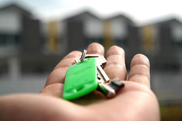 Hand in foreground holding house keys