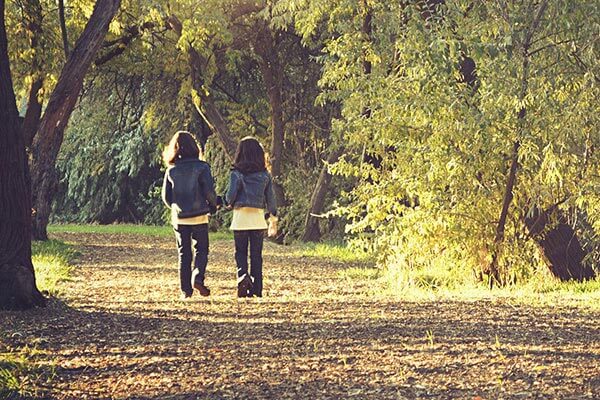 Two children walking in the woods